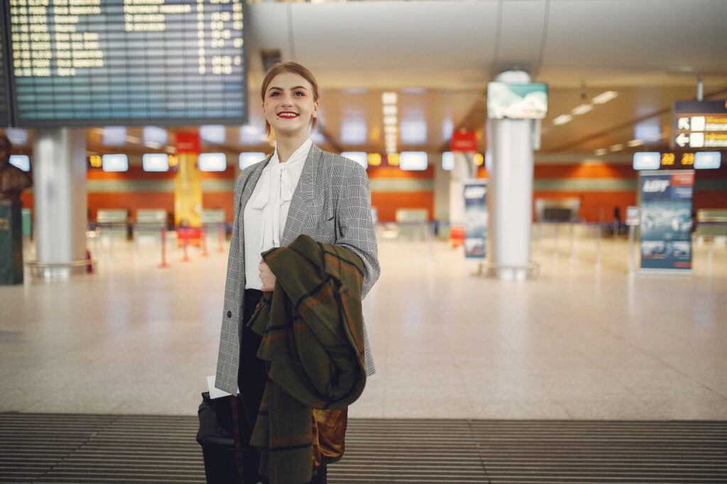 Smiling traveler with a suitcase at the airport