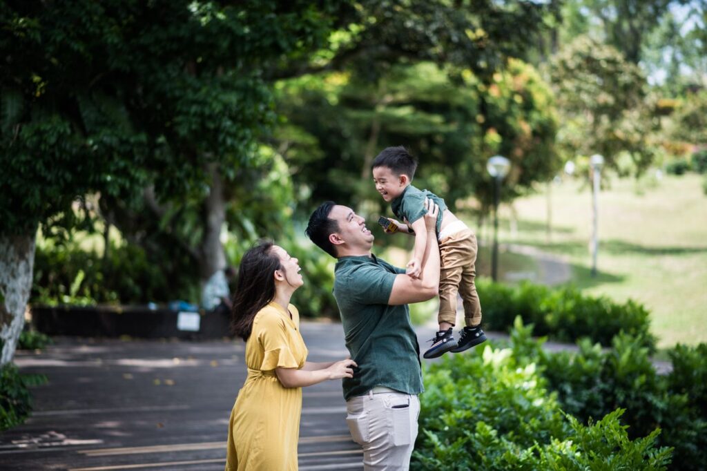 Parents lifting their young son in a park