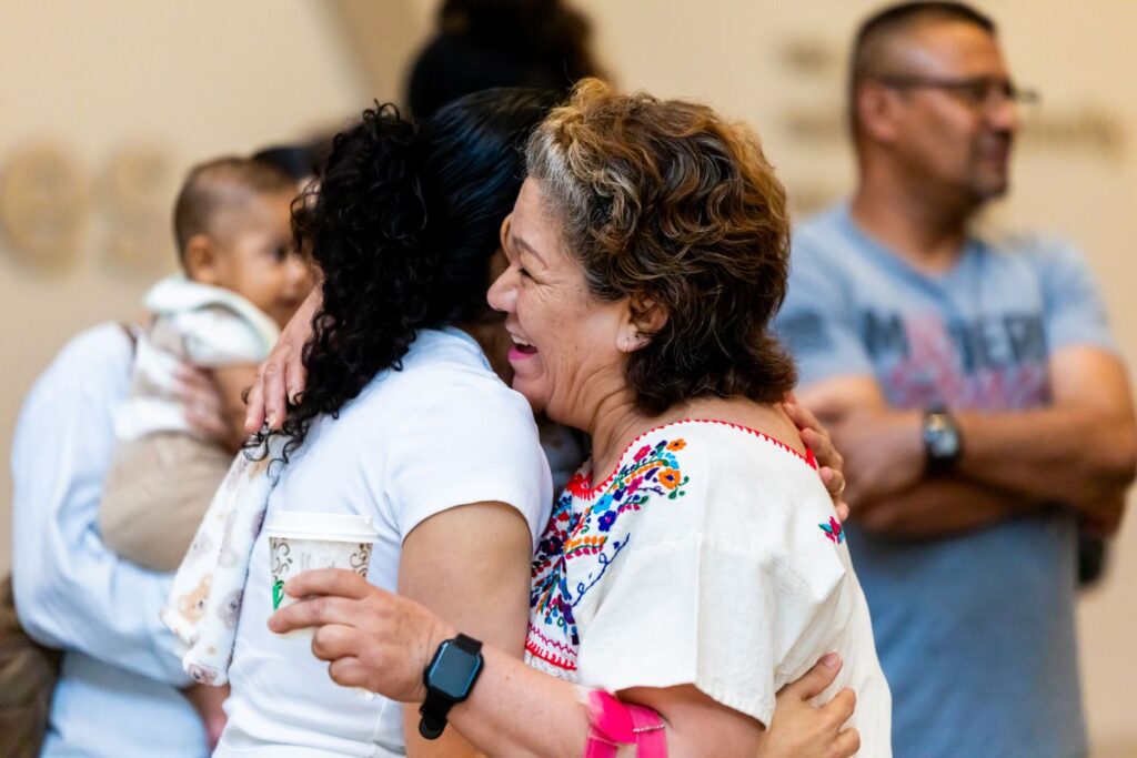 Grandmother embracing a family member in an emotional reunion