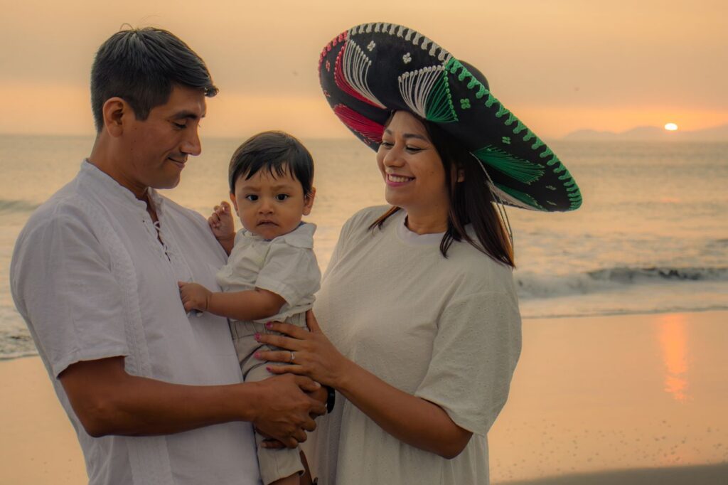 Familia con un niño pequeño en la playa al atardecer