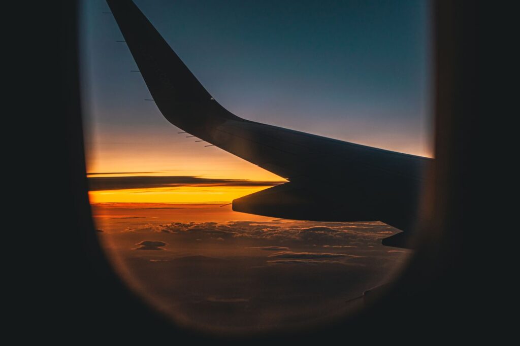 Vista del ala de un avión al atardecer desde la ventanilla